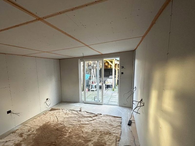 The extension boarded, with tape on every plasterboard joint and cables hanging ready