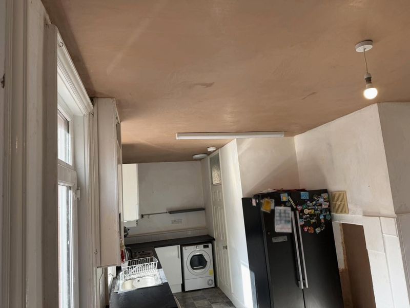 The kitchen ceiling finished in fresh plaster, smooth from wall to wall