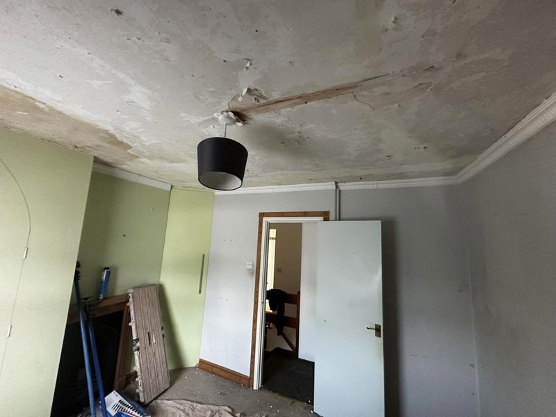 The bedroom from the other side, cracked ceiling above the door and wardrobe