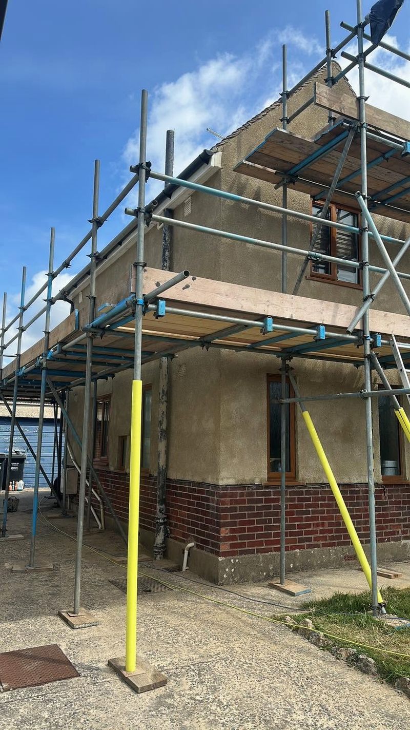 The same end of the house on scaffolding with fresh render on the walls