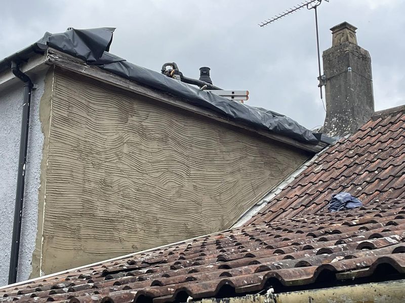 The dormer cheek with a scratched base coat of render